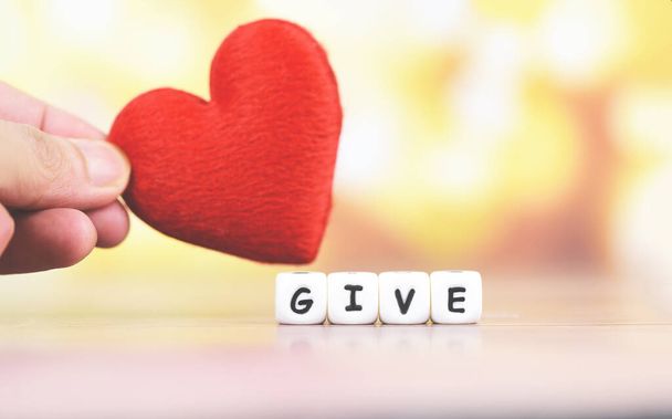 Dê amor com coração vermelho na mão para doar e filantropia hea
 - Foto, Imagem