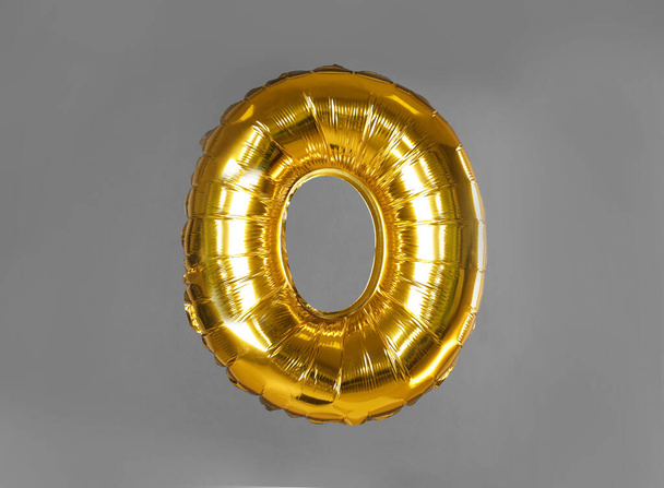 Golden letter O balloon on grey background - 写真・画像
