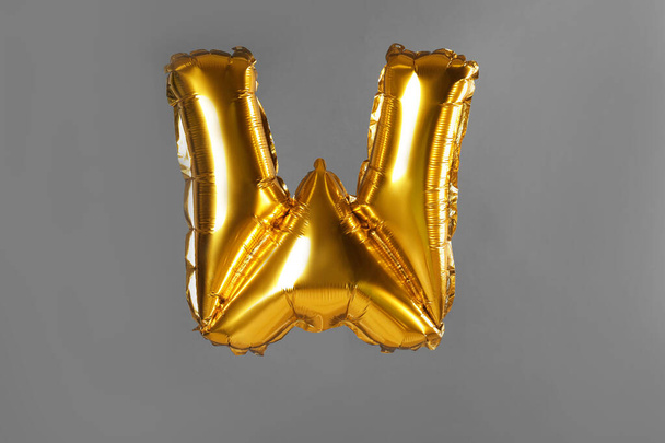 Golden letter W balloon on grey background - Foto, immagini