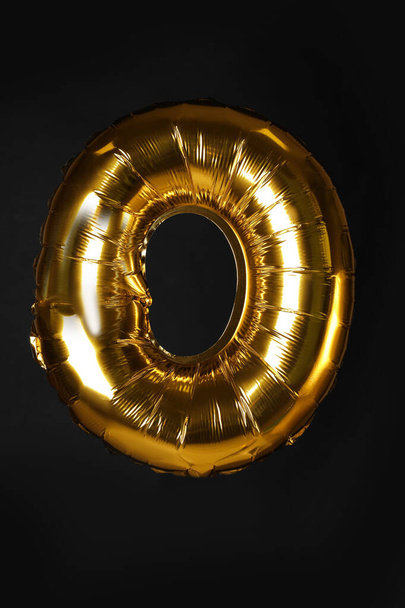 Golden letter O balloon on black background - 写真・画像