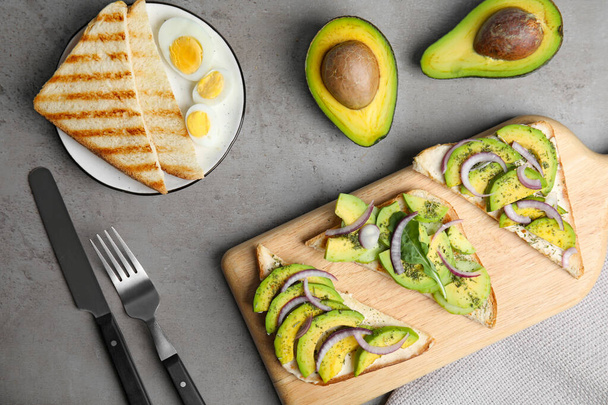 Flat lay composition with avocado toasts on grey table - Photo, image