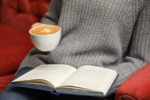 Frau mit Tasse Kaffee Lesebuch auf Sofa, Nahaufnahme - Foto, Bild