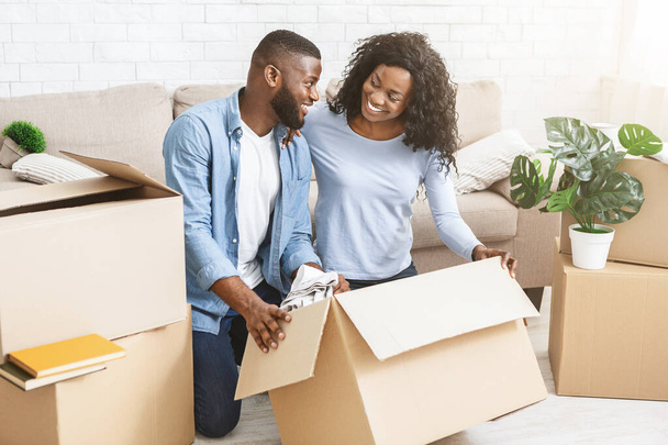 Emocionada pareja negra preparándose para mudarse
 - Foto, Imagen