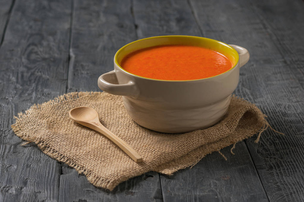 Puree soup with a wooden spoon on a piece of burlap on a wooden table. - Photo, Image