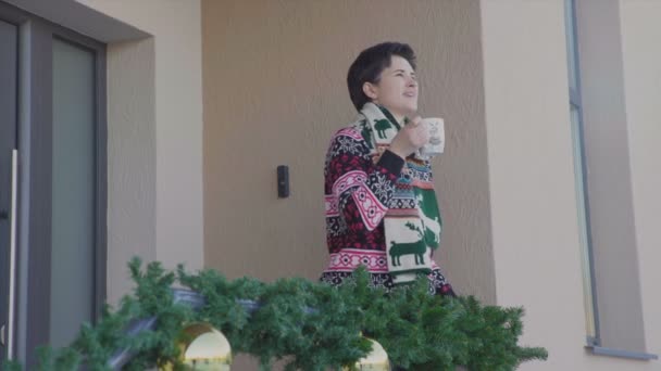 Žena pít kakao na dvorku o vánočních prázdninách - Záběry, video