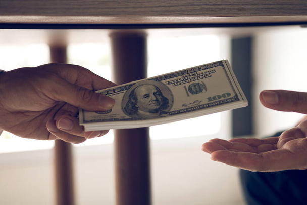 Podnikatelé dostávají peníze pod stůl, který je úplatek - Fotografie, Obrázek