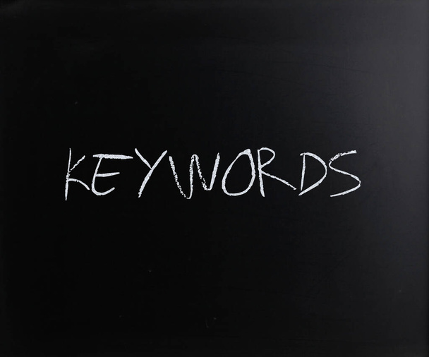 Le mot "mots clés" écrit à la main avec de la craie blanche sur un tableau noir
 - Photo, image