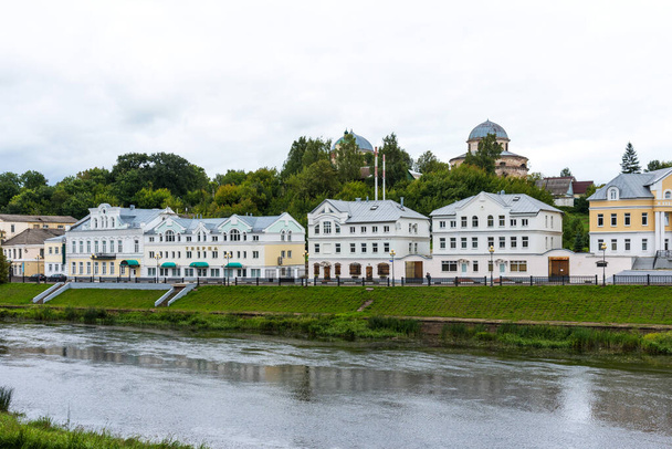 Torzhok, Russia - August 4, 2019: Panoramic summer view of the embankment of the Tvertsa river with old buildings in Torzhok, Russia. - Photo, image
