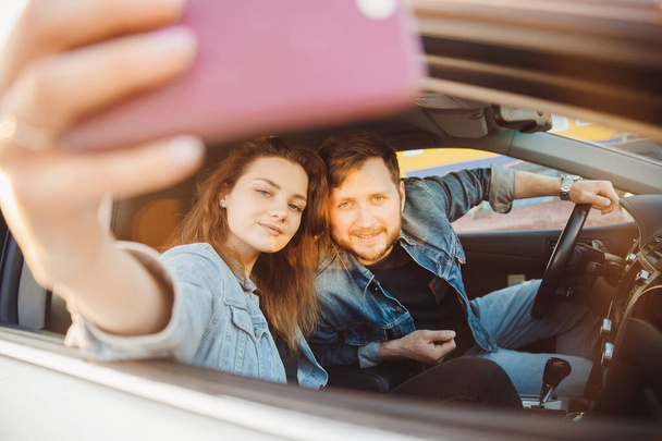 車の中でカップルの若い男と女性を愛するセルフィーの写真。コンセプト旅行夏旅行 - 写真・画像