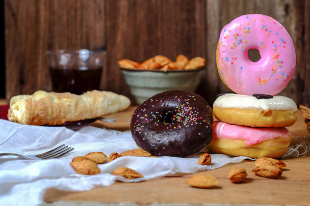 Delicious colorful donuts food on wooden background. - Zdjęcie, obraz