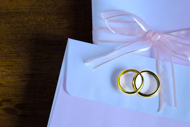 Duo golden wedding ring over invice card on wood table.Wedding c - Foto, Bild