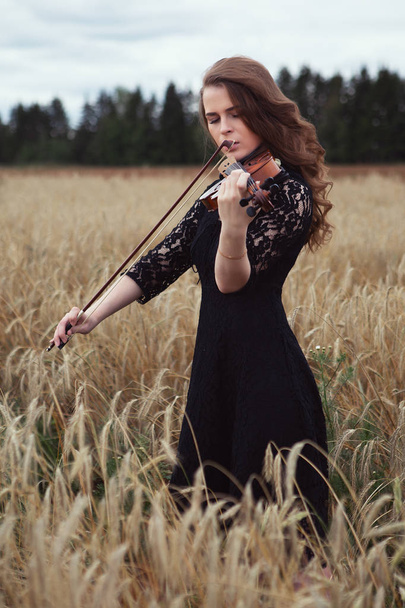 sad young woman playing violin romantic work in nature - Фото, зображення