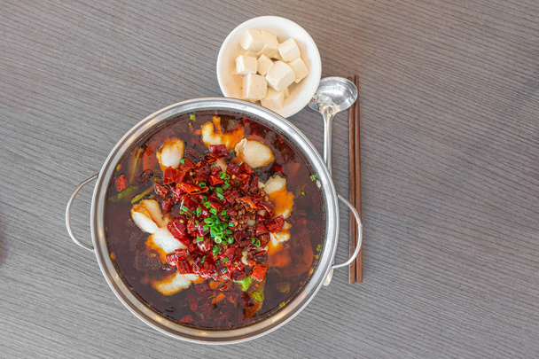 Sichuan spicy boiled fish hot pot with red hot spicy chilli. Asia China Chongqing Chengdu food. Flat lay top down view. - Foto, immagini