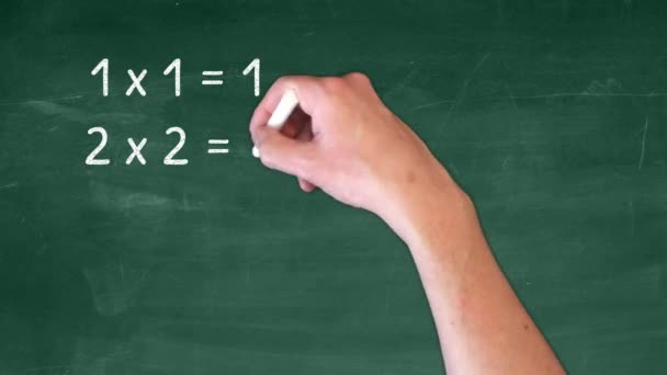 matematyka podstawowa - ręka z kredą pisze mnożenie na tablicy - Materiał filmowy, wideo
