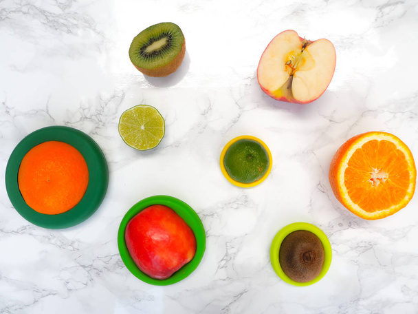 Owoce krojone z kolorowymi silikonowymi foliami spożywczymi wielokrotnego użytku, które redukują marnotrawstwo żywności i utratę żywności przy zerowym zużyciu odpadów - Zdjęcie, obraz