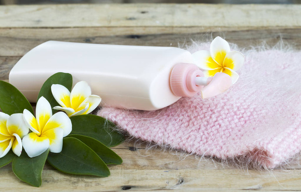 herbal cosmetics body lotion heath care for body skin with knitting wool scarf of lifestyle woman relax in winter season and flowers franigpani arrangement flat lay style on background wooden - Photo, Image