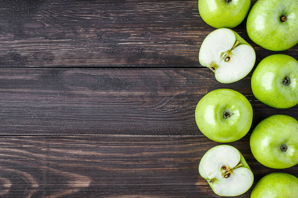 Ripe green apples and apple slices on old wooden background.Vege - Foto, afbeelding