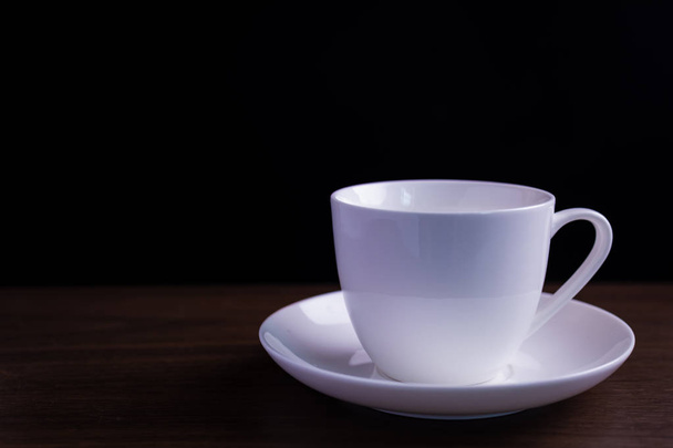 The coffee cup on the table has a black background - Photo, Image