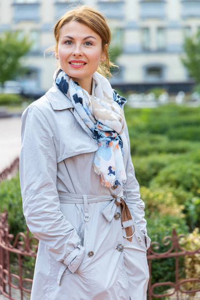 Portrait of a beautiful middle-aged woman on the background of the city and park. - Foto, Bild
