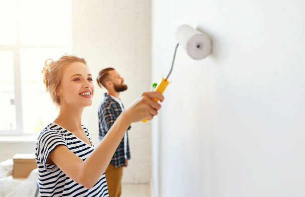молода щаслива пара ремонтує і фарбує стіну вдома
 - Фото, зображення