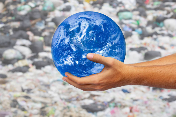 Les mains des hommes tenant le globle sur fond de poubelle. Concept écologique, jour de la Terre. Éléments de cette image fournis par la NASA
 - Photo, image