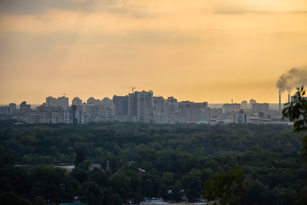 Ronde van Kiev in het centrum van Europa. Uitzicht op de Dnjepr, Truchanov eiland en een voetgangersbrug. Park fontein en zonsondergang aan de horizon - Foto, afbeelding