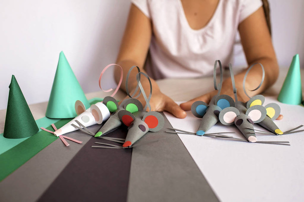 Schattig 7-8 jaar oud meisje maken van vervaardigde muizen met gekleurd papier - Foto, afbeelding