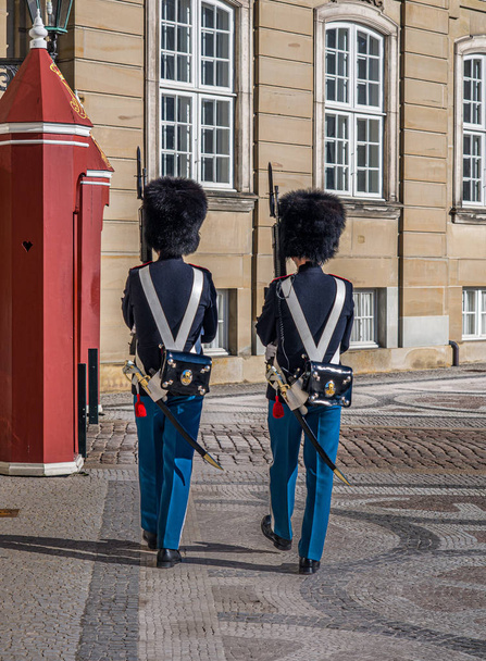 Δύο φρουροί σε επιφυλακή φρουρούν Amalenborg ή Royal Palace επίσημη κατοικία της δανικής βασιλικής οικογένειας στην Κοπεγχάγη, - Φωτογραφία, εικόνα