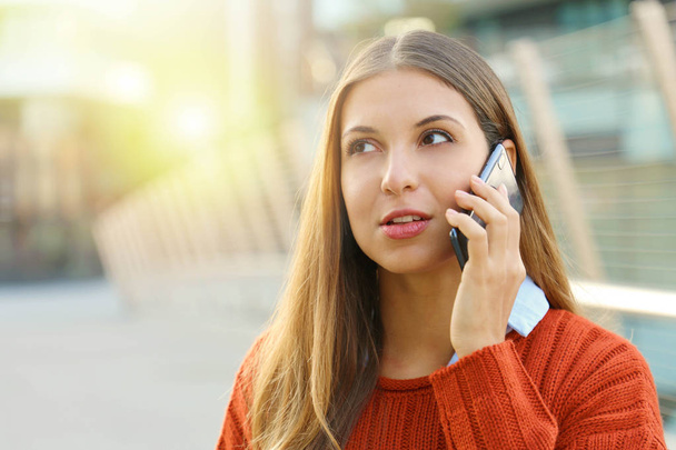 Primo piano di donna che parla al telefono prendendo una conversazione in autunno su sfondo strada moderna
. - Foto, immagini