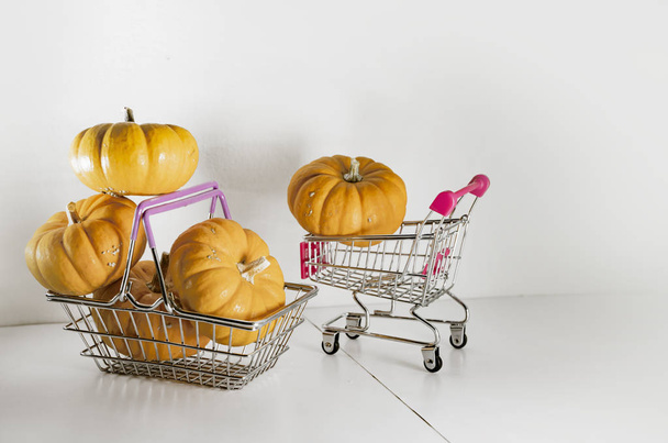 Halloween pompoenen in mand van de supermarkt als symbool van vakantie kortingen en herfst verkoop - Foto, afbeelding
