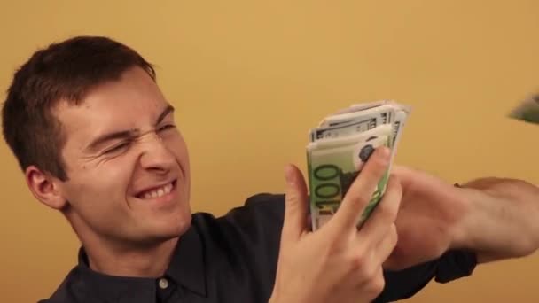 a man in a shirt throws money on a beige background - Footage, Video