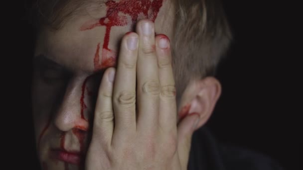 Portrét Halloweena. Chlápek s kapající krví na tváři. Děsivý make-up - Záběry, video