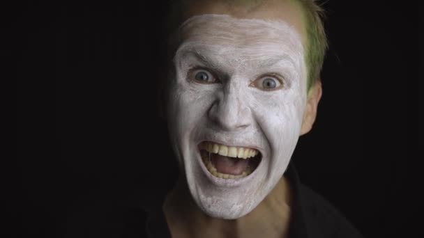 Portrét klauna Halloweena. Detailní záběr tváře zlých klaunů. Bílý make-up obličeje - Záběry, video
