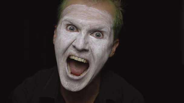 Clown Halloween uomo ritratto. Primo piano di una faccia da pagliaccio malvagio. Trucco viso bianco
 - Filmati, video