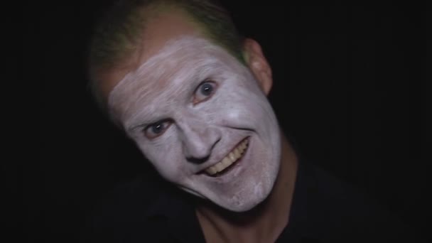 Bohóc Halloween férfi portré. Közelkép egy gonosz bohóc arcáról. Fehér arc smink - Felvétel, videó