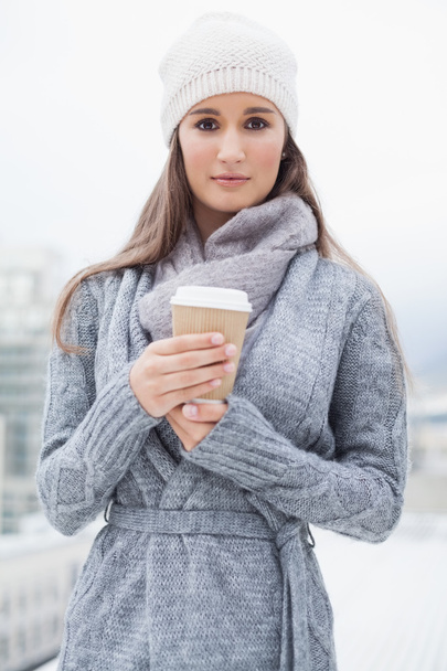 Peaceful pretty brunette with winter clothes on holding coffee - Foto, Imagem