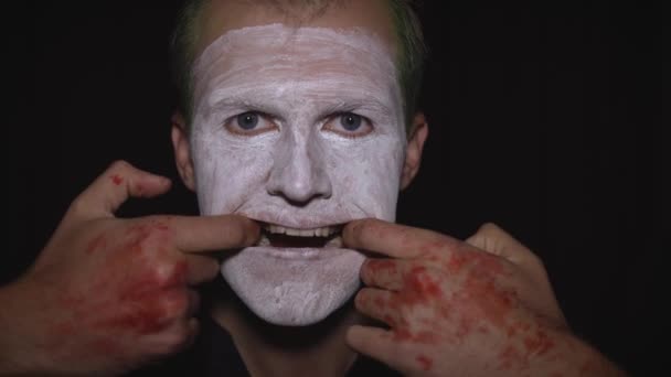 Portret klauna Halloween. Zbliżenie na twarz złego klauna. Biały makijaż twarzy - Materiał filmowy, wideo