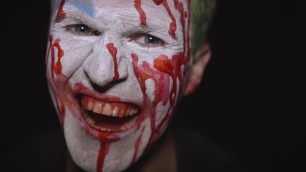 Portrét klauna Halloweena. Strašidelná, zlá klaunská krvavá tvář. Bílý make-up obličeje - Záběry, video