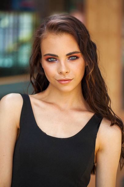 Make-up schoonheid. Close-up portret jonge brunette vrouw in zwart  - Foto, afbeelding