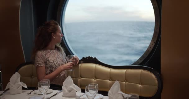 Nő nézi Sunset From window Luxus Cruise Ship egy pohár bort. - Felvétel, videó