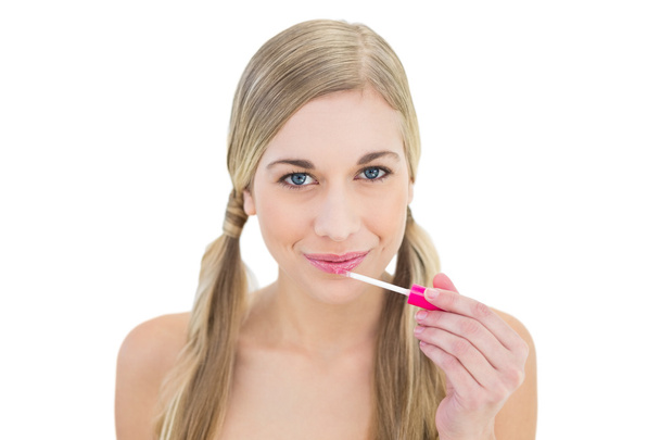 Amused young blonde woman applying gloss - Photo, Image