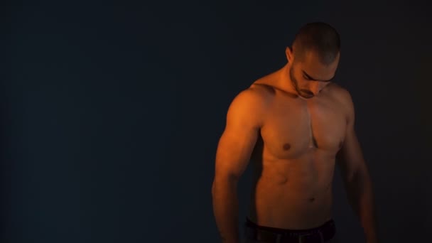 Stüdyoda siyah arka planda poz veren erkek fitness modeli, iyi biçimli kasları gösteriyor - Video, Çekim