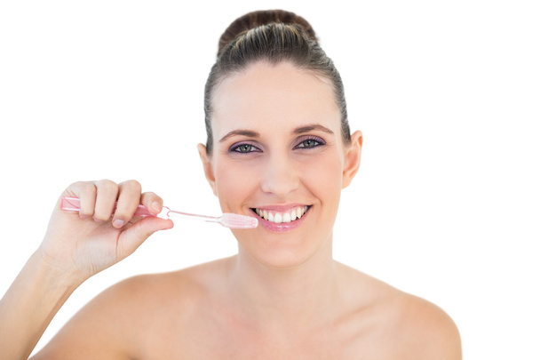 Smiling pretty woman brushing her teeth - Foto, imagen