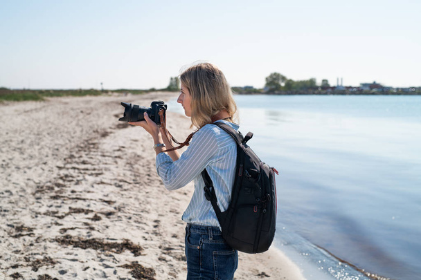 Femme photographiant depuis une plage
 - Photo, image