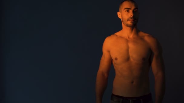 Çekici fitness modeli siyah arkaplana karşı harika bir vücut gösteriyor - Video, Çekim