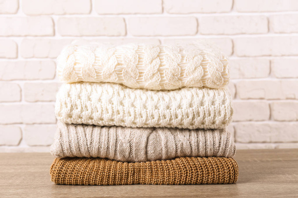 Pile of knitted sweaters of different colors and patterns perfectly stacked. - Foto, Imagen