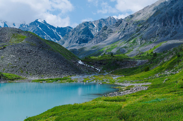 Lago de color turquesa entre los picos de montaña. Río de alta montaña en el día de verano, senderismo en rocas y piedras
 - Foto, imagen
