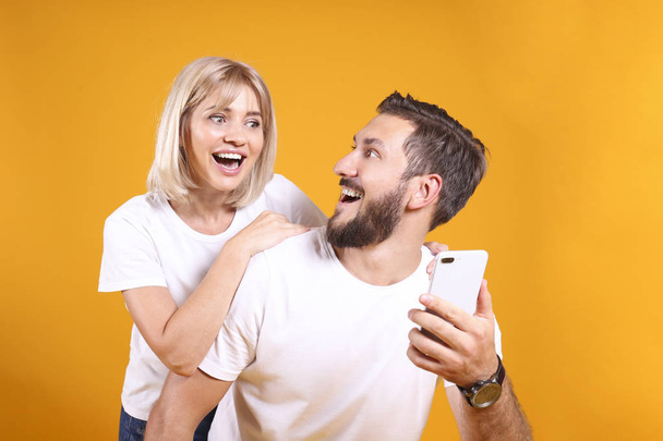 Young people of opposite sex and hair color on yellow background. - Φωτογραφία, εικόνα