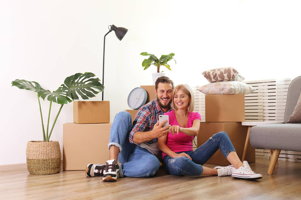 Young married couple moving in new apartment, sitting on the flo - Φωτογραφία, εικόνα