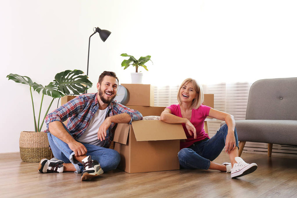 Young married couple moving in new apartment, sitting on the flo - Φωτογραφία, εικόνα